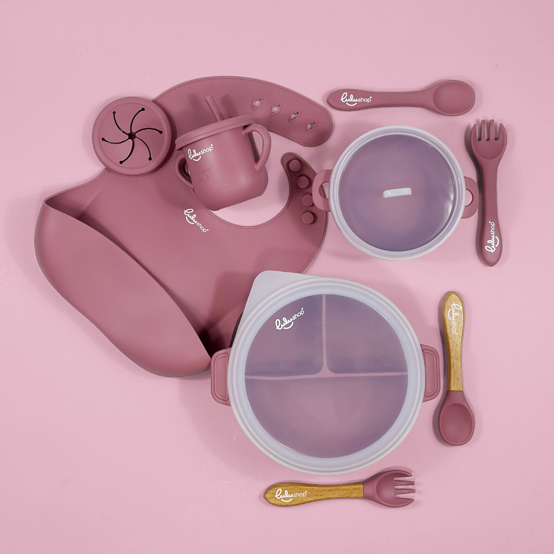 Lulushop 9-piece baby feeding set in Pink Daisy, featuring silicone suction plate, bowl, bib, cup, and utensils.